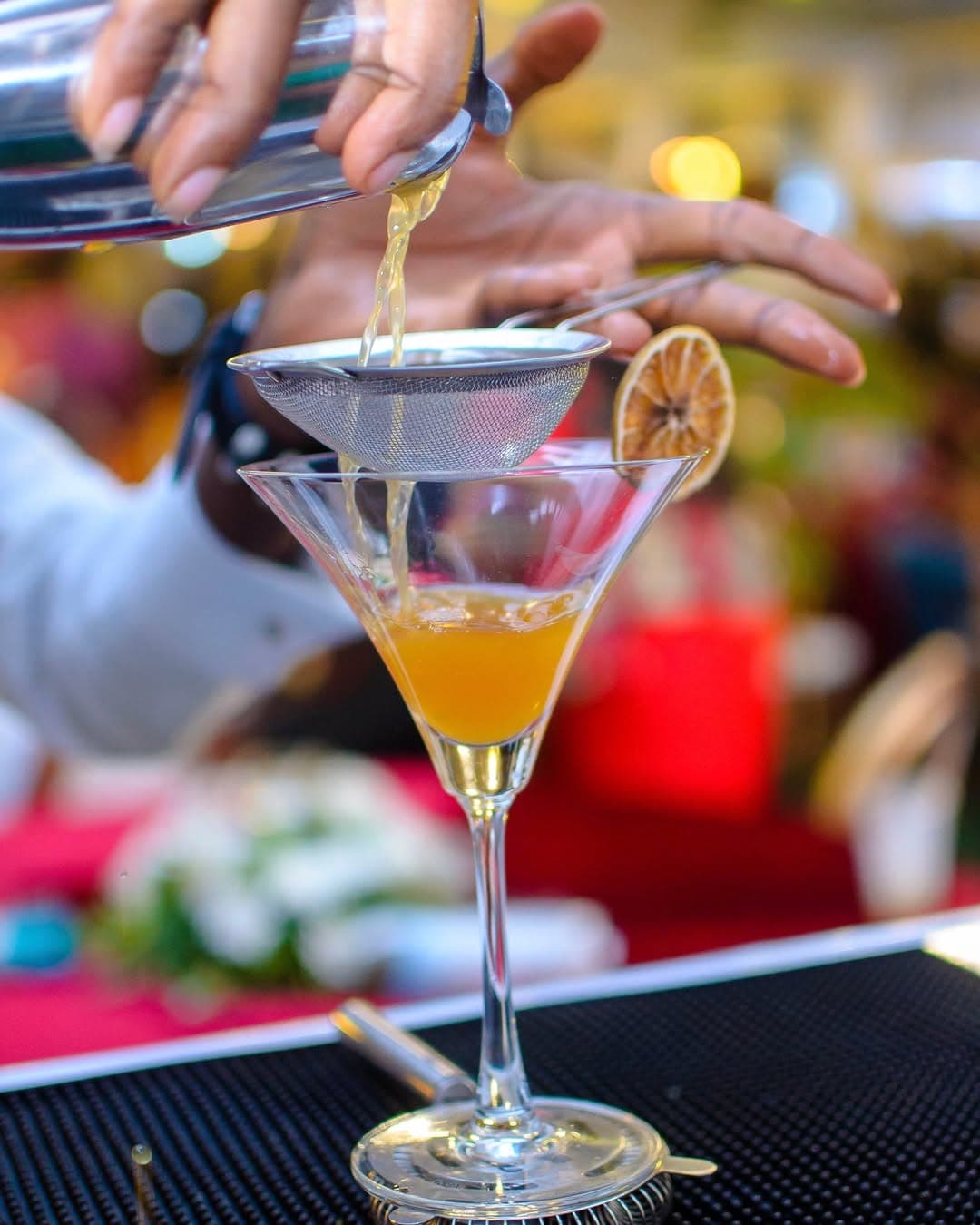 A Limehouse bartender pouring a cocktail into a net